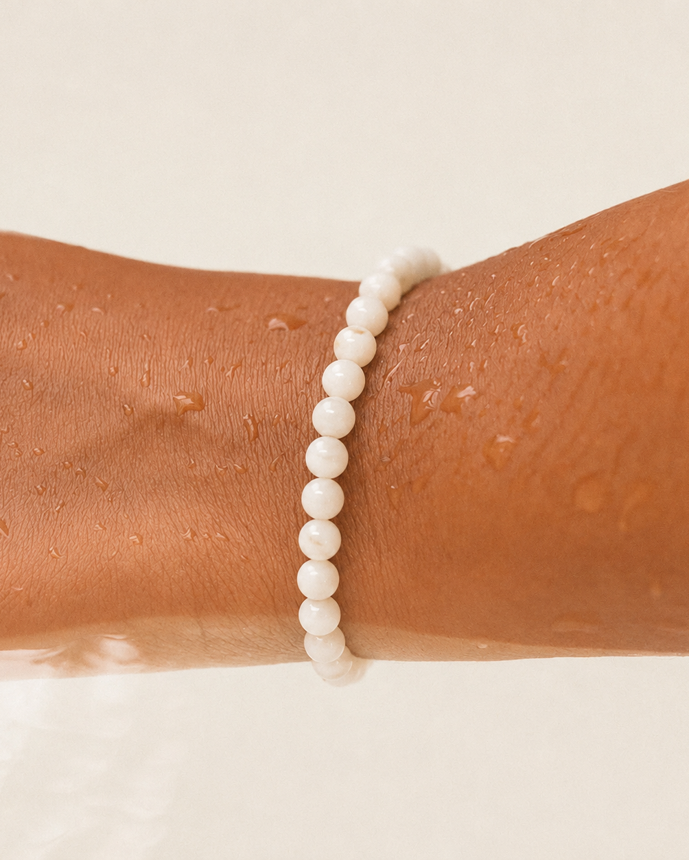 Styled view of Soft Tide White Shell Bracelet by AURAM with white shell beads for coastal layering