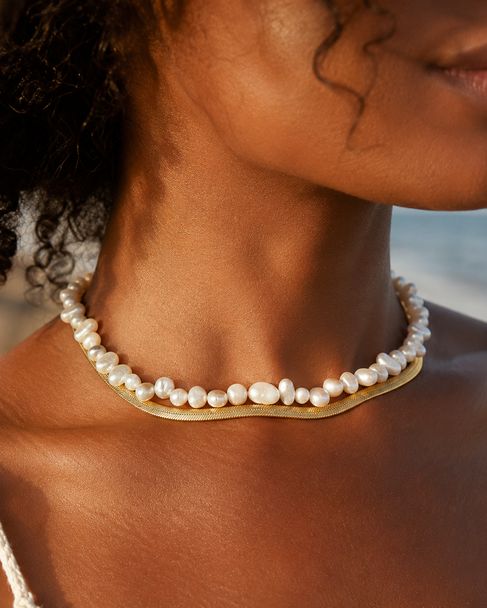 Styled view of Mini Baroque Pearl Choker by AURAM with small organic pearls for modern layering